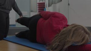 Instructor assisting client one to one pilates recovery