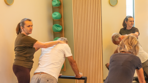 Instructor assisting client one to one pilates recovery