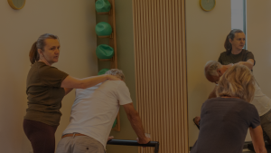 Instructor assisting client one to one pilates recovery